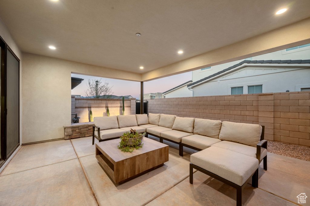 Patio terrace at dusk with a fenced backyard and outdoor lounge area