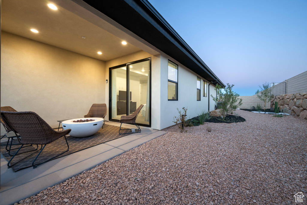 Exterior space featuring a patio area, an outdoor fire pit, stucco siding, and fence private yard