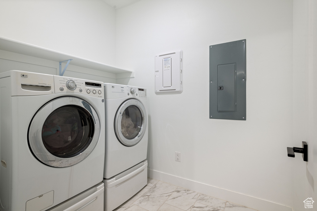 Washroom with laundry area, separate washer and dryer, marble finish floor, baseboards, and electric panel