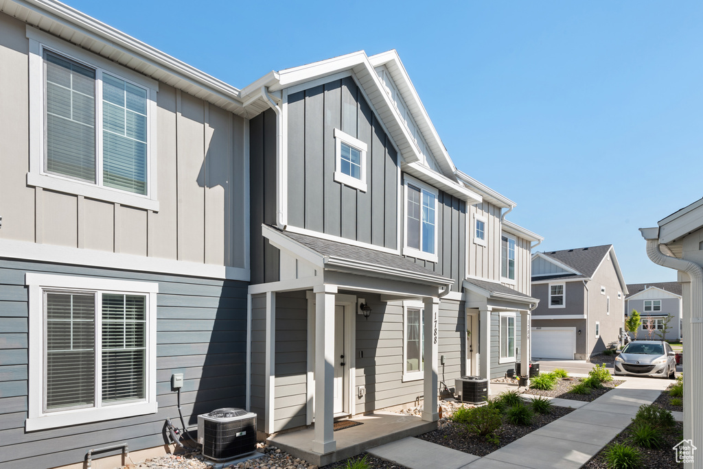View of front facade with central AC unit, board and batten siding, and a residential view