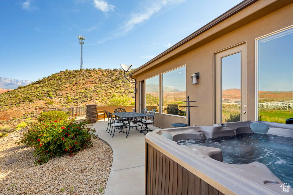 View of patio featuring a hot tub and a mountain view