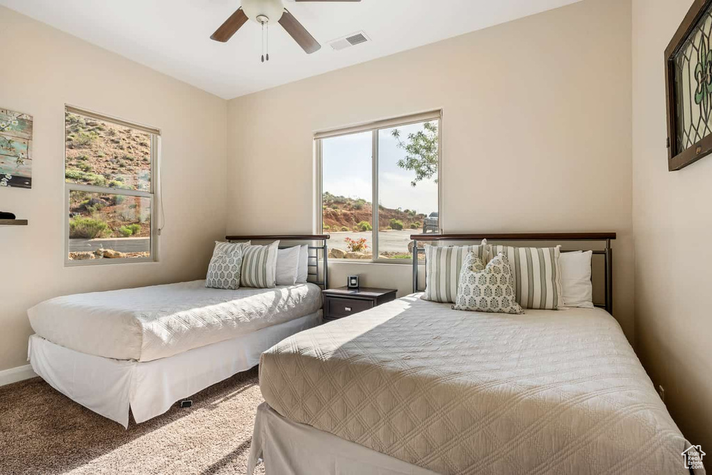 Bedroom with carpet floors, ceiling fan, and visible vents