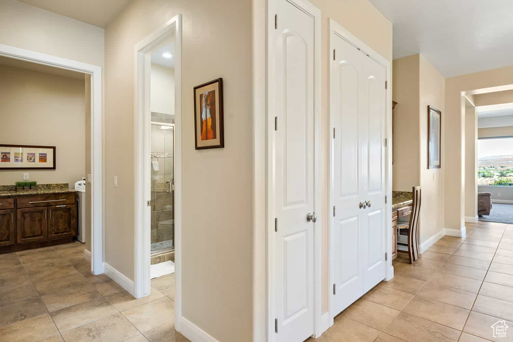 Hallway with baseboards and light tile patterned floors