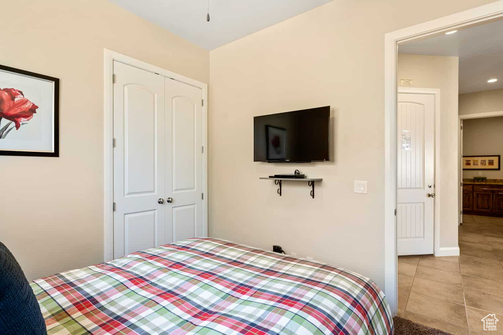Bedroom featuring a closet, recessed lighting, baseboards, and light tile patterned floors