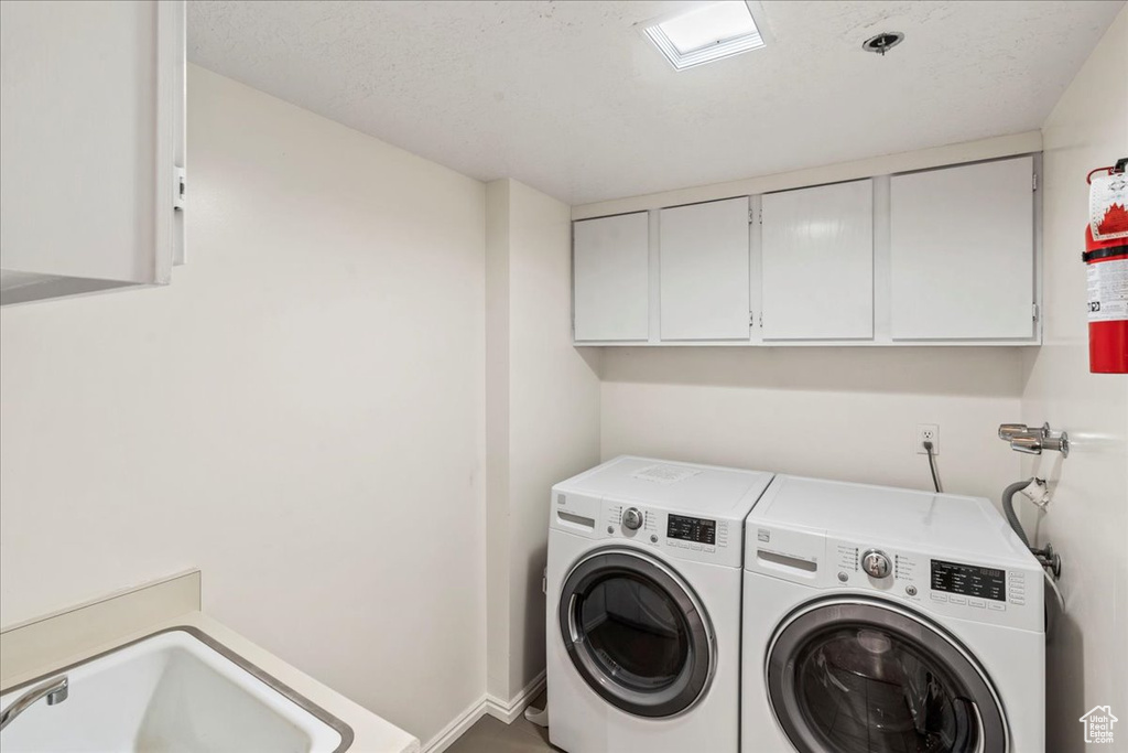 Laundry area featuring baseboards, cabinet space, and washer and dryer