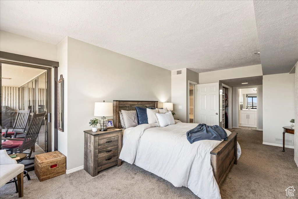 Bedroom featuring visible vents, a textured ceiling, baseboards, and light colored carpet