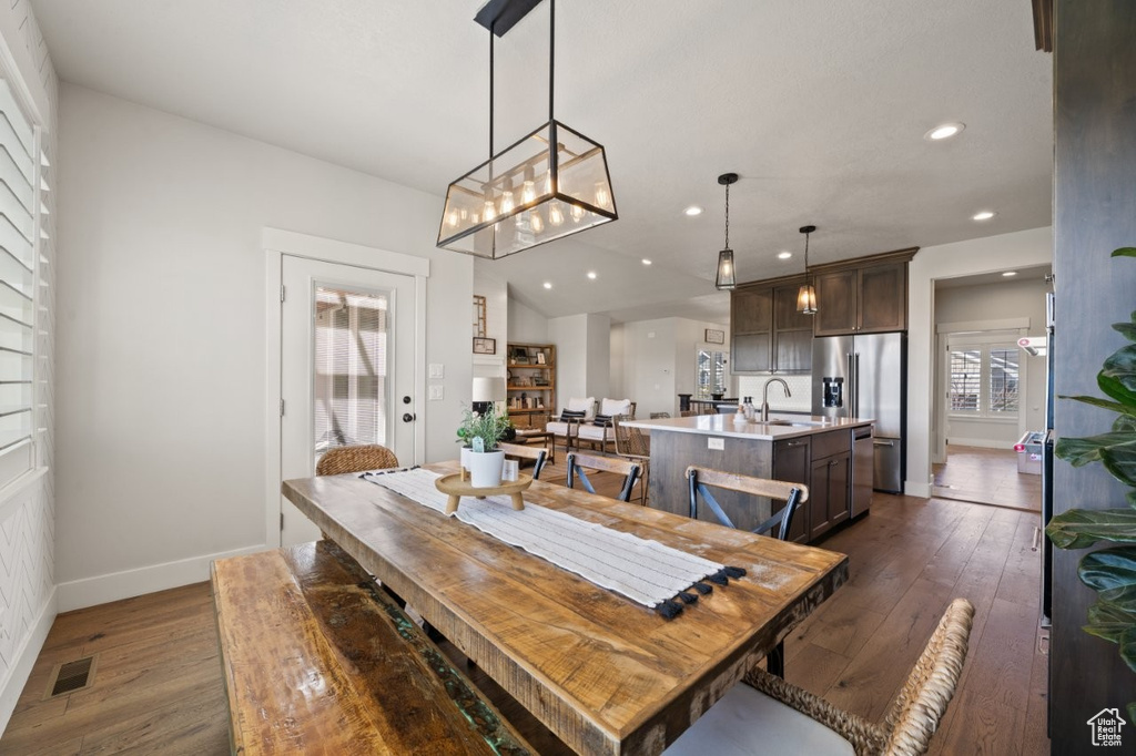 Dining room featuring dark wood-style flooring, a notable chandelier, recessed lighting, baseboards, and visible vents