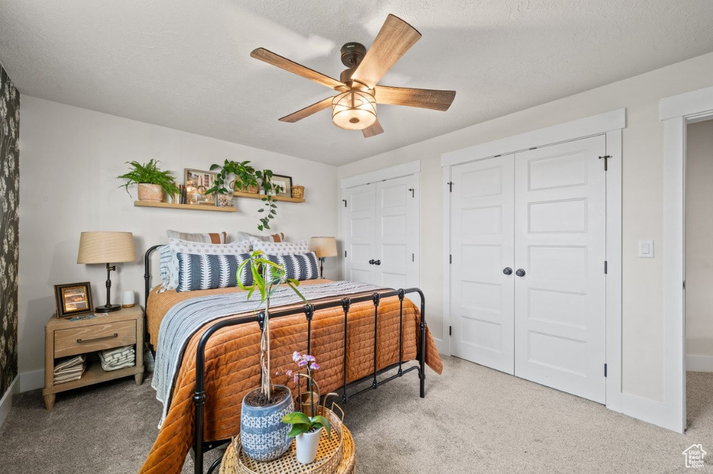 Bedroom featuring light colored carpet, multiple closets, and baseboards