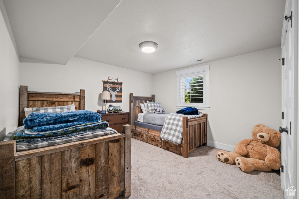 Carpeted bedroom featuring baseboards and visible vents