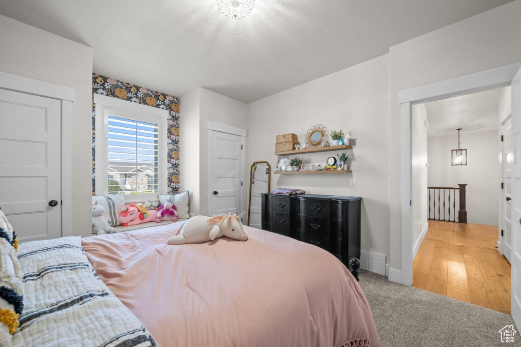 Bedroom featuring baseboards, visible vents, and light colored carpet