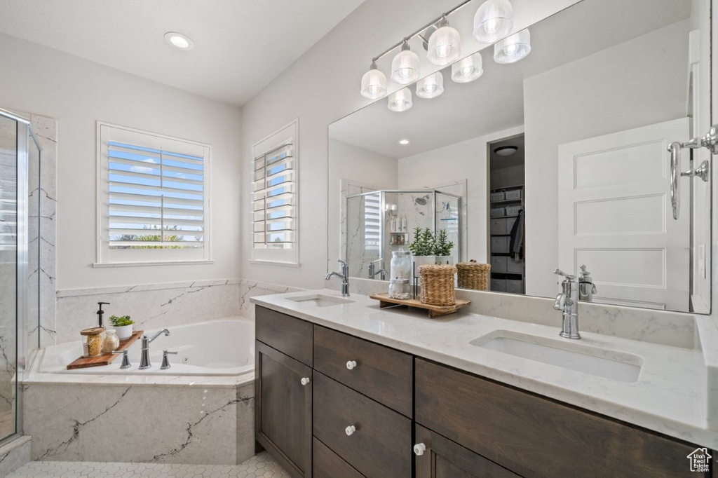 Bathroom featuring double vanity, a sink, a marble finish shower, and a bath