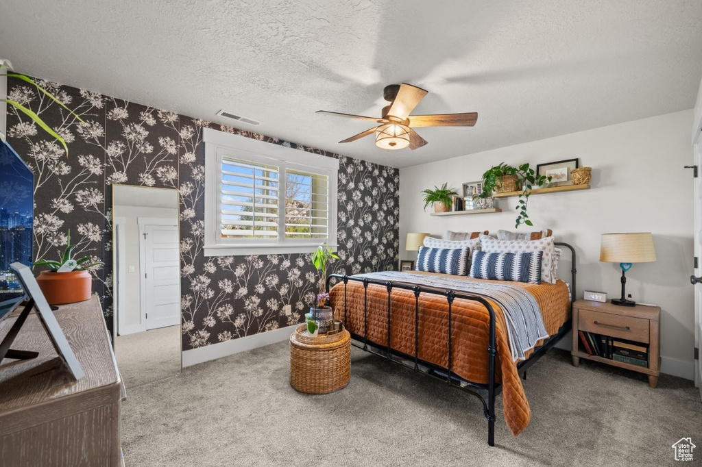 Bedroom with visible vents, carpet floors, baseboards, wallpapered walls, and a ceiling fan