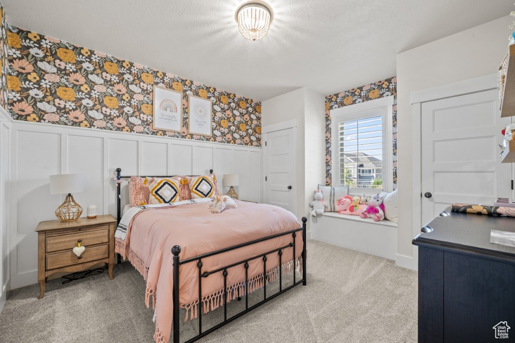 Carpeted bedroom with a decorative wall, a wainscoted wall, and wallpapered walls