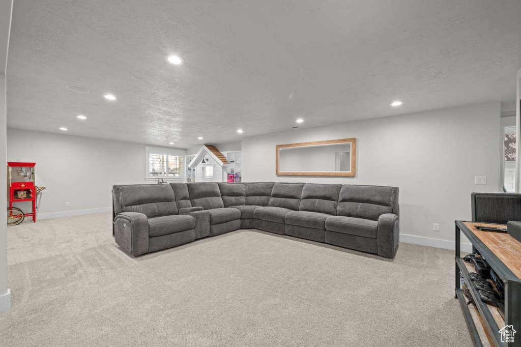 Living room with light colored carpet, recessed lighting, and baseboards