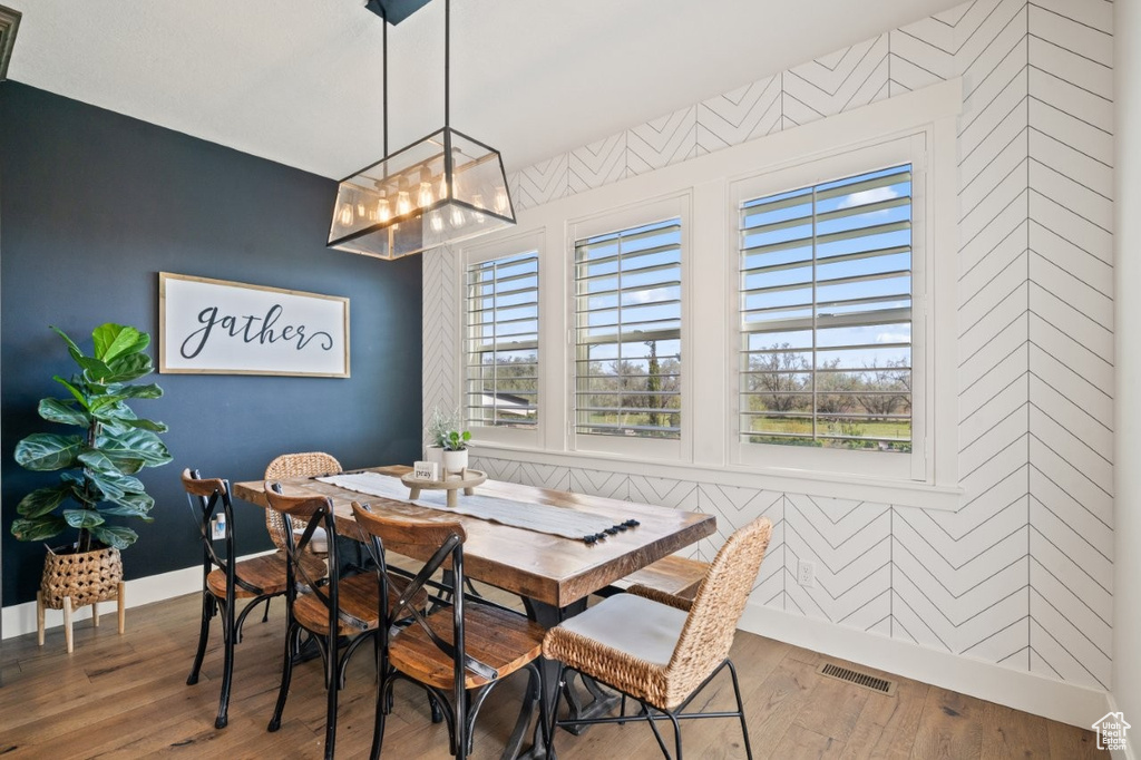 Dining room featuring visible vents, baseboards, an accent wall, and a chandelier