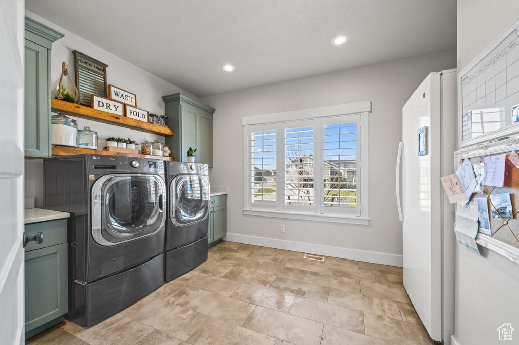 Washroom featuring recessed lighting, baseboards, independent washer and dryer, and cabinet space