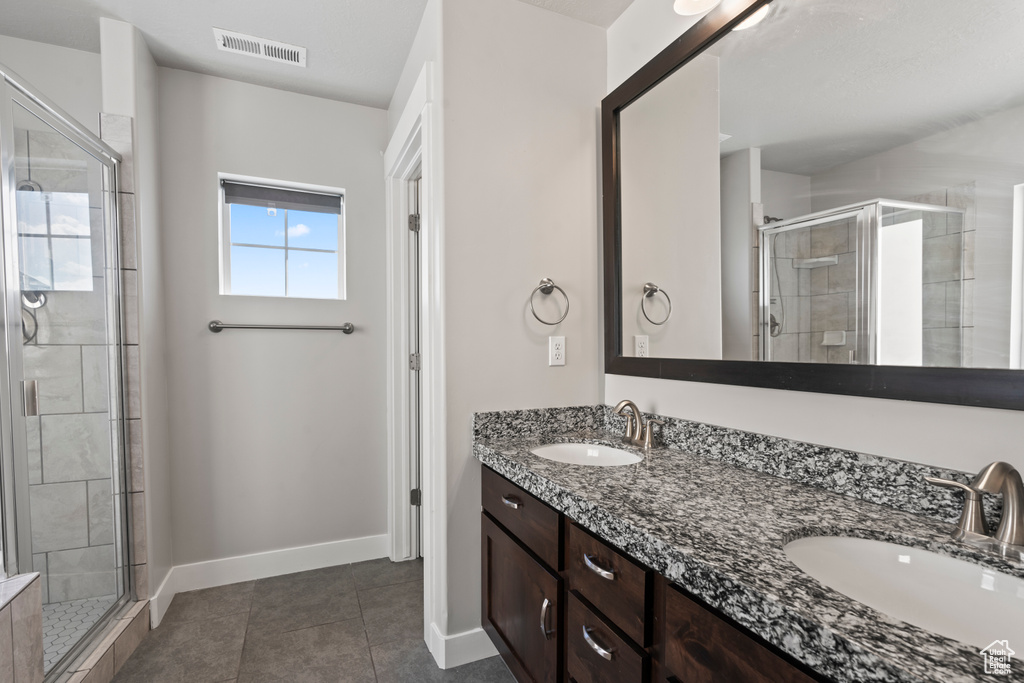 Bathroom featuring visible vents, a sink, tile patterned flooring, and a shower stall