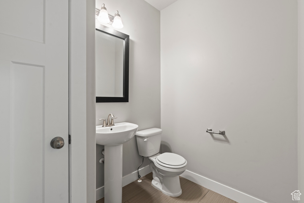 Bathroom with toilet, baseboards, and a sink