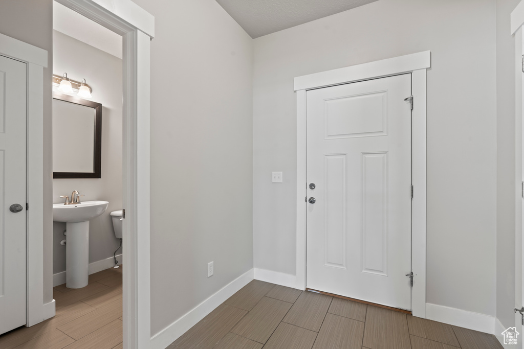 Entrance foyer with baseboards and wood finish floors