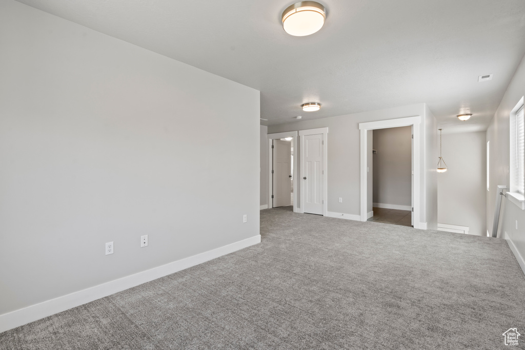 Carpeted spare room with baseboards and visible vents