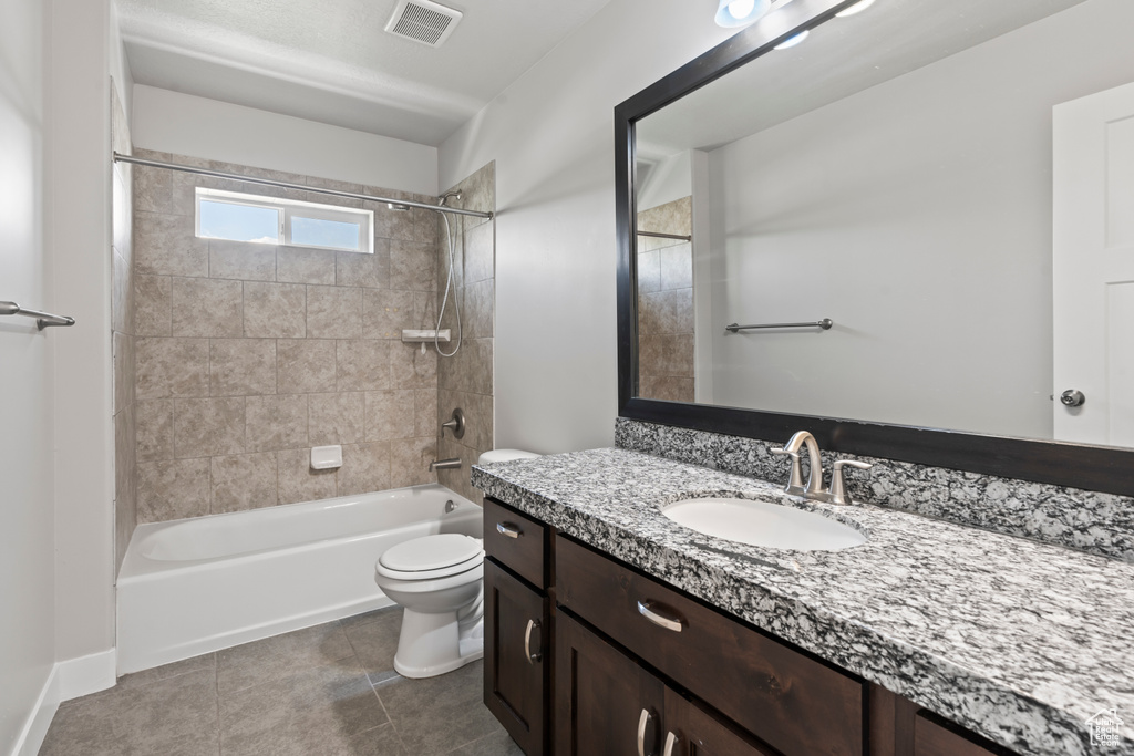 Bathroom with visible vents, tile patterned flooring, vanity, toilet, and shower / bath combination