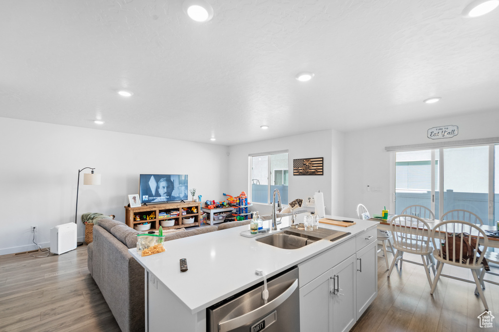 Kitchen with a sink, recessed lighting, light wood finished floors, and dishwasher