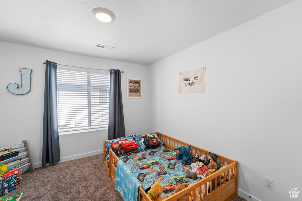 Bedroom with carpet floors, baseboards, and visible vents