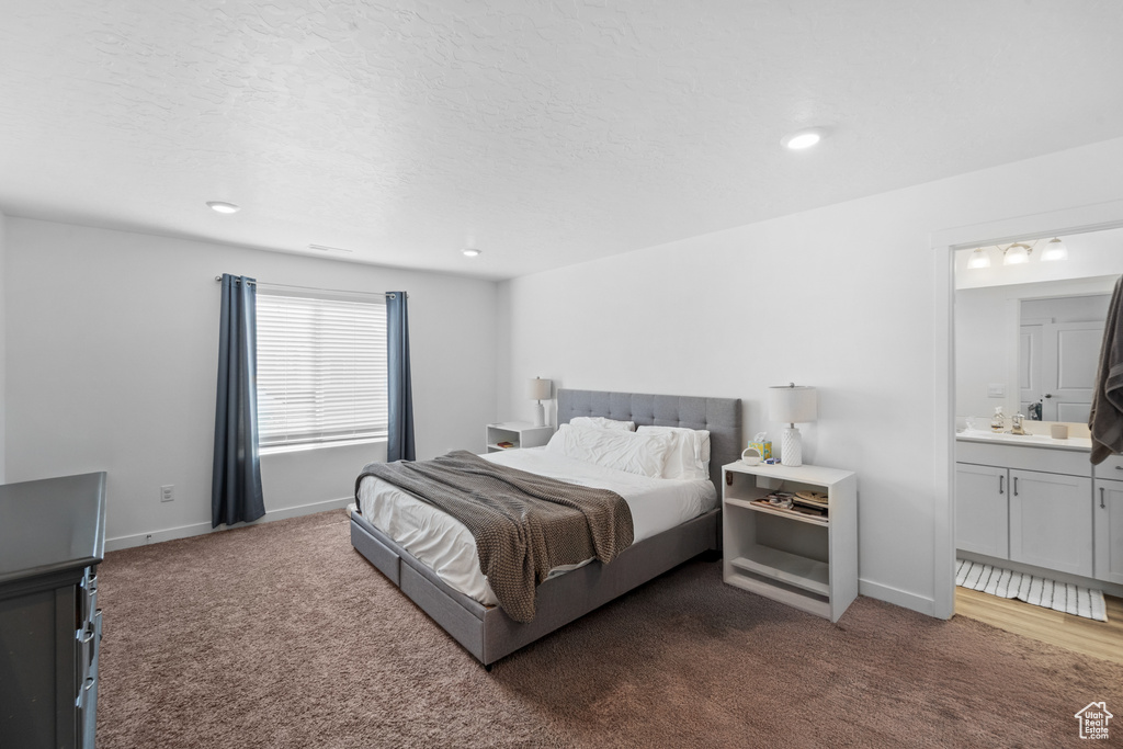 Bedroom with a sink, baseboards, carpet, and ensuite bath