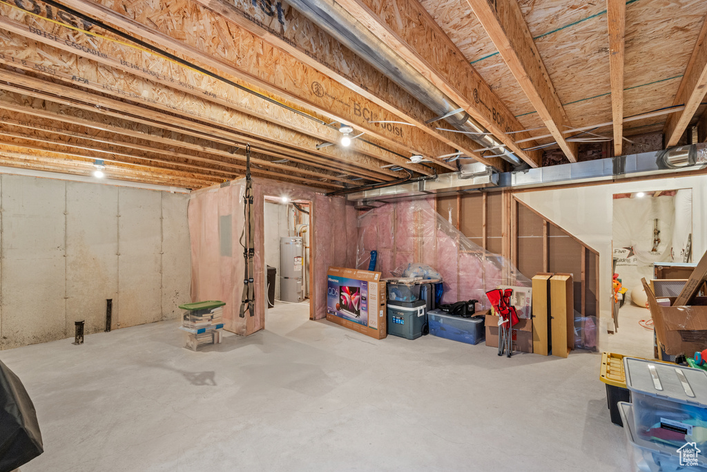 Unfinished below grade area featuring water heater