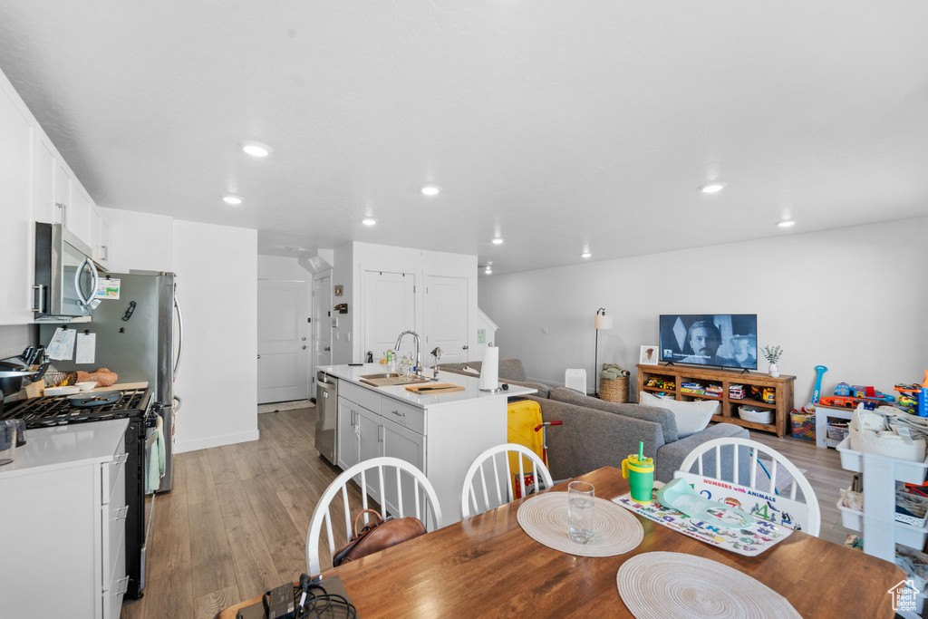 Dining area with recessed lighting and light wood-style flooring