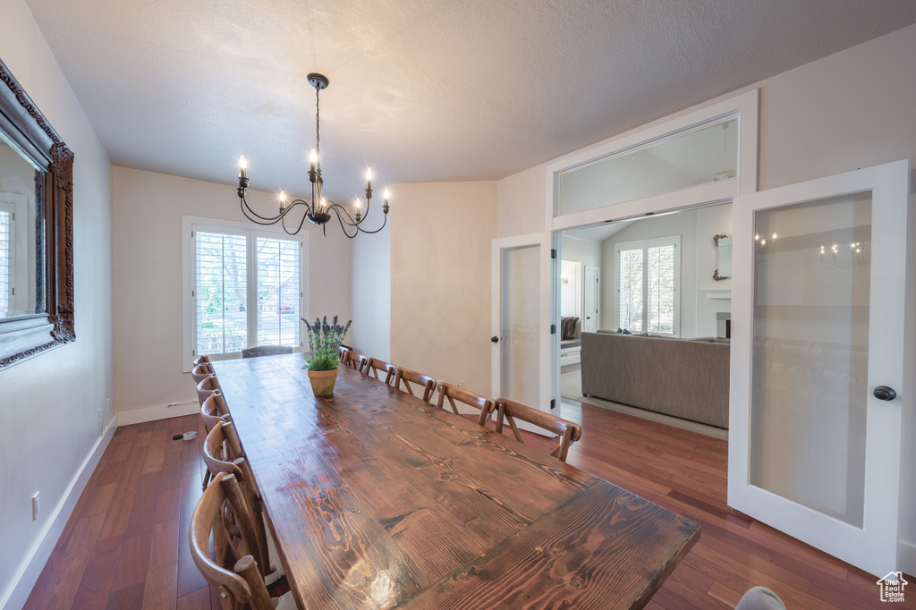 Dining room with an inviting chandelier, baseboards, dark wood-style floors, and french doors