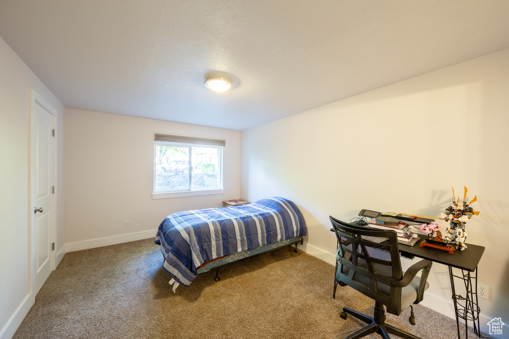 Bedroom featuring carpet floors and baseboards