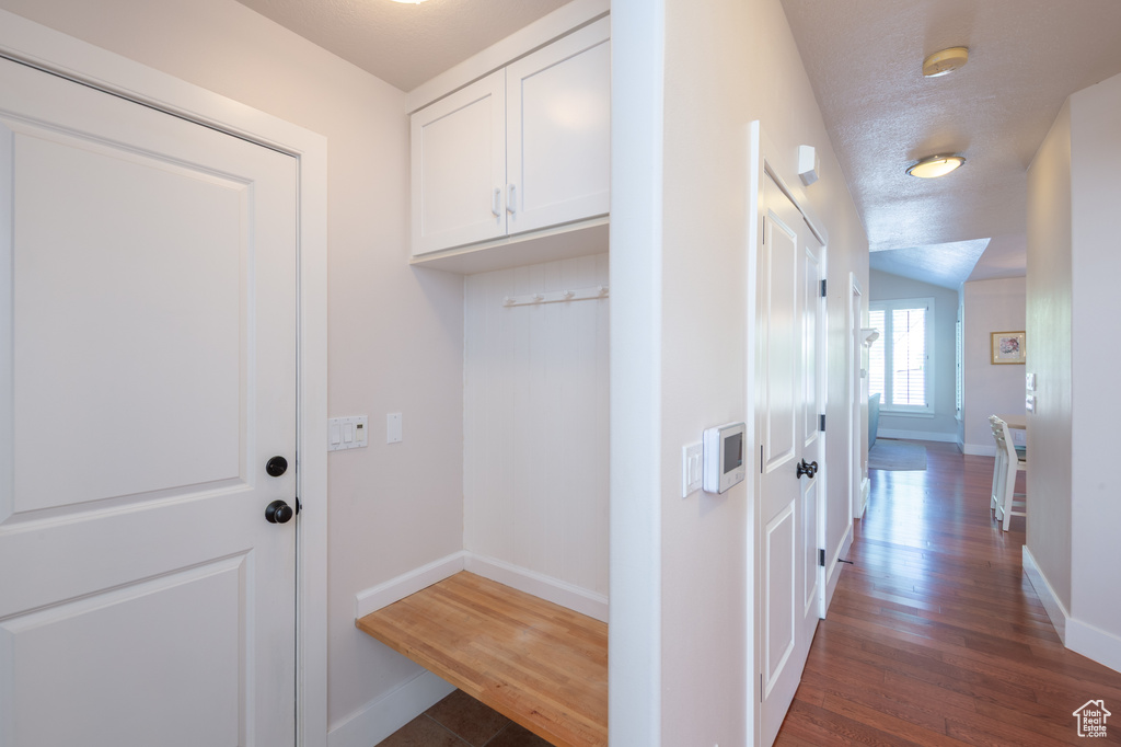 Interior space featuring baseboards, cabinet space, and dark wood-type flooring