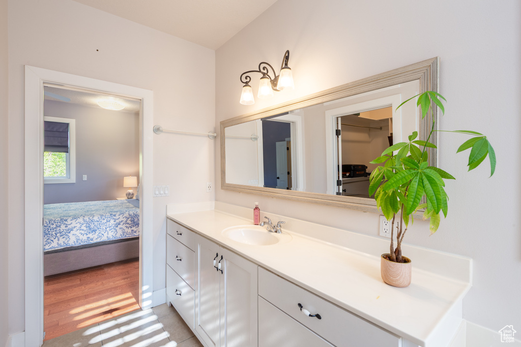 Bathroom featuring vanity, connected bathroom, and wood finished floors