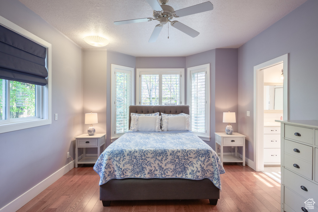 Bedroom featuring a textured ceiling, baseboards, a ceiling fan, and light wood finished floors