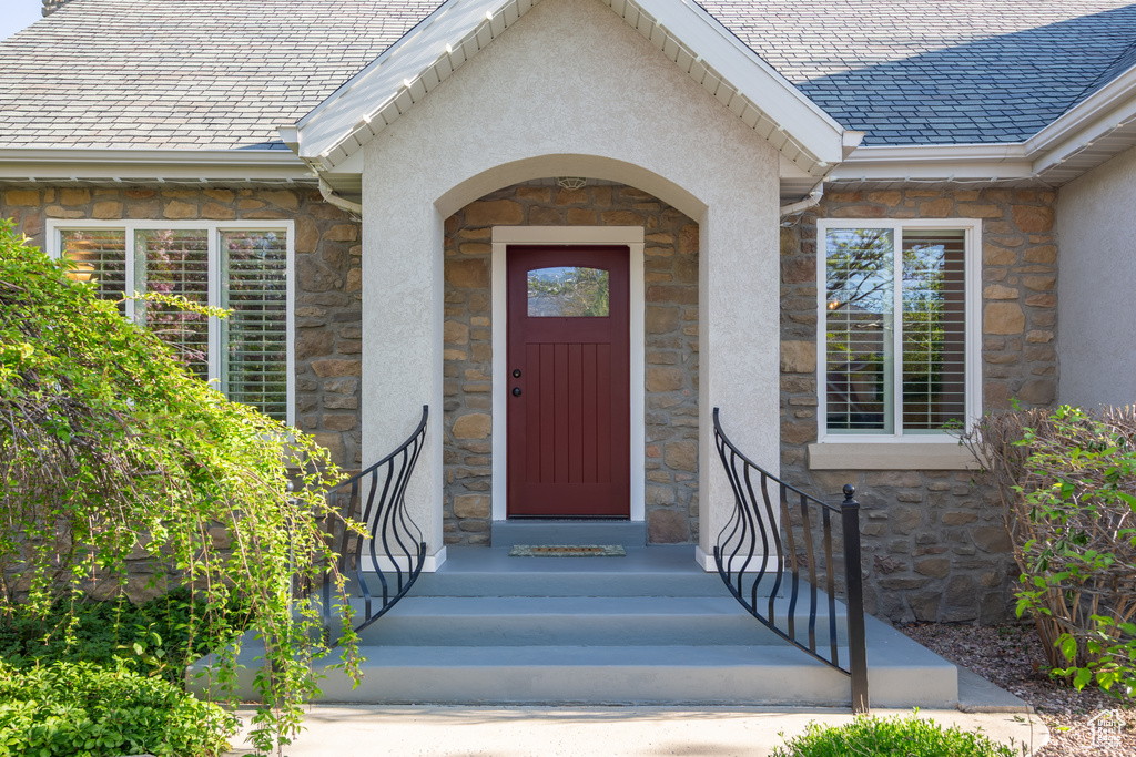 Property entrance featuring stucco siding and stone siding