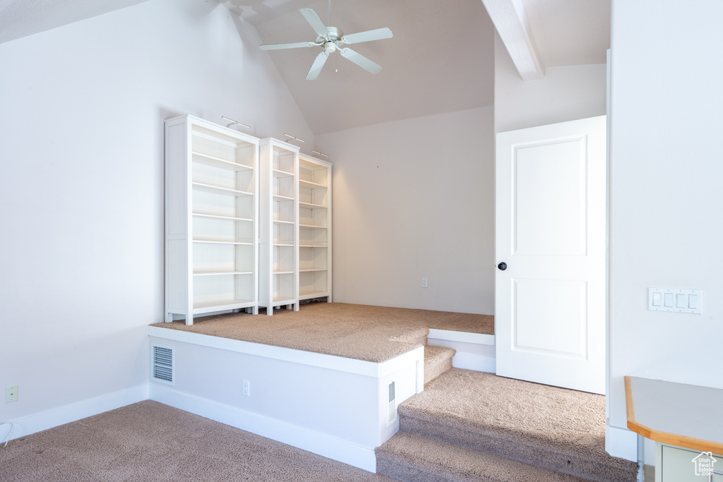 Interior space with ceiling fan, visible vents, and vaulted ceiling with beams