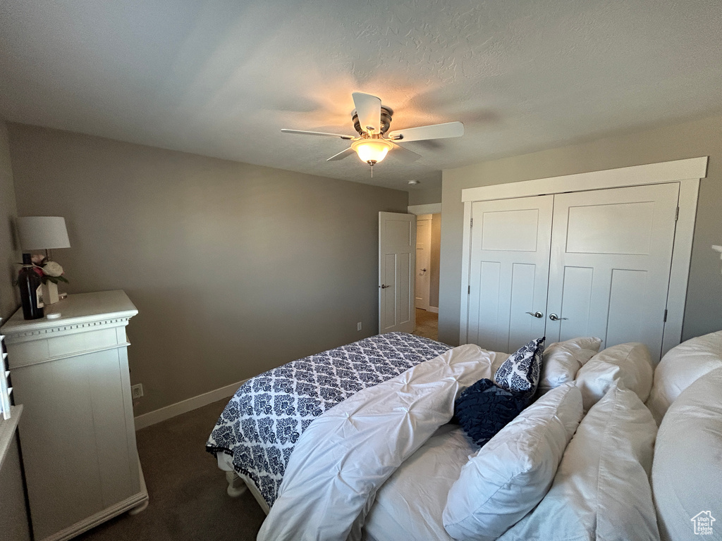 Bedroom featuring a ceiling fan, baseboards, carpet, and a closet