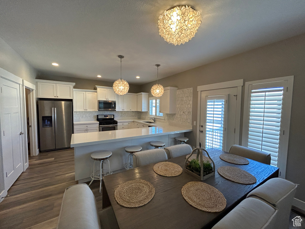 Dining room with recessed lighting, dark wood finished floors, and a notable chandelier