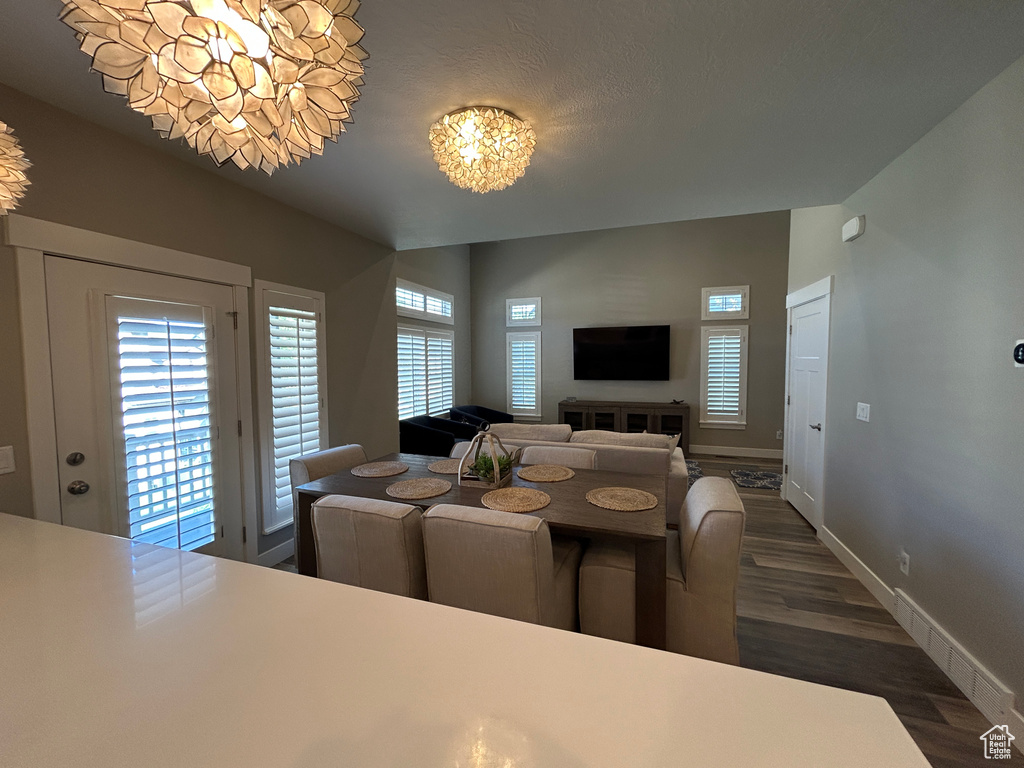 Dining room featuring an inviting chandelier, baseboards, and wood finished floors