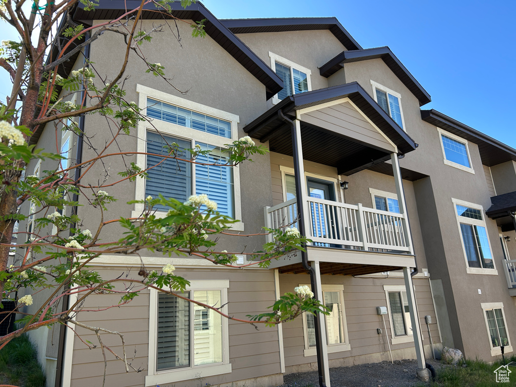 Back of property featuring a balcony and stucco siding