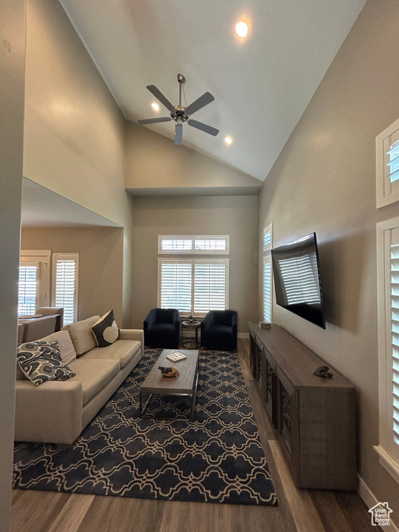 Living room with high vaulted ceiling, a ceiling fan, baseboards, recessed lighting, and wood finished floors