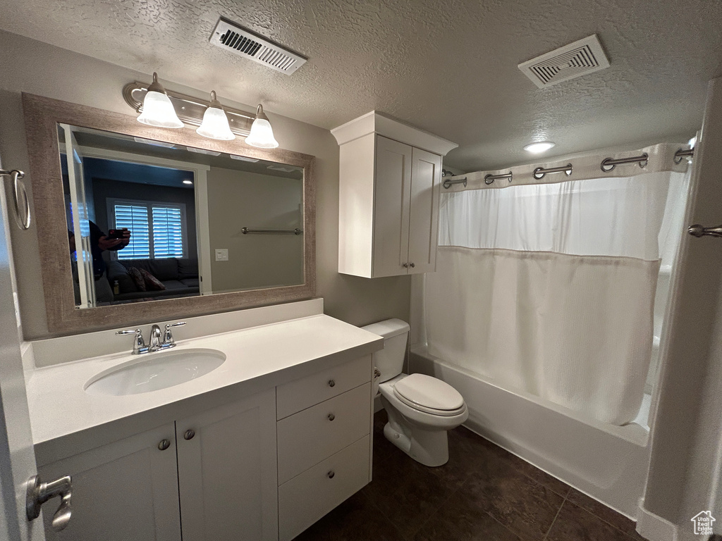Full bath with visible vents, shower / bath combo with shower curtain, toilet, and vanity