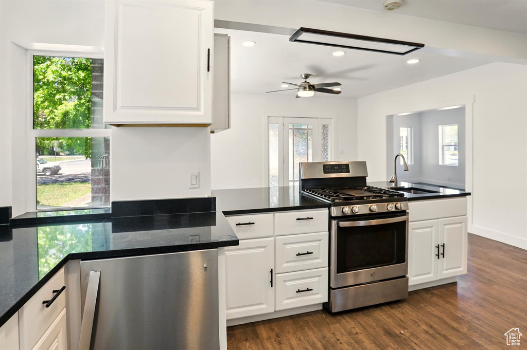 Kitchen with a sink, white cabinets, stainless steel gas range oven, and a wealth of natural light