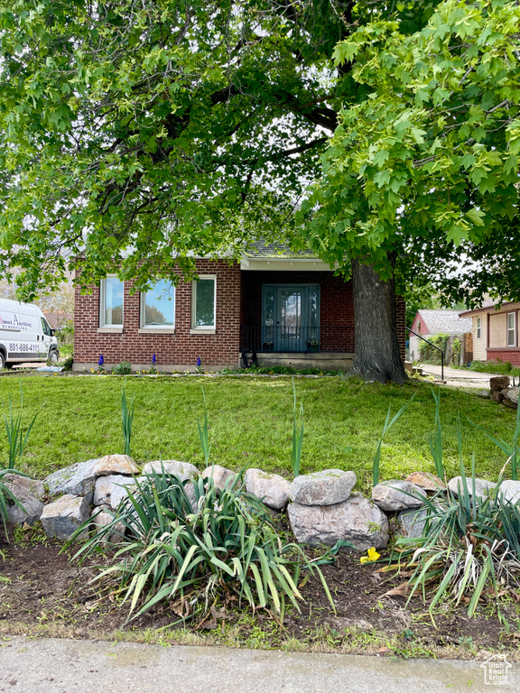 View of front facade featuring a front lawn and brick siding