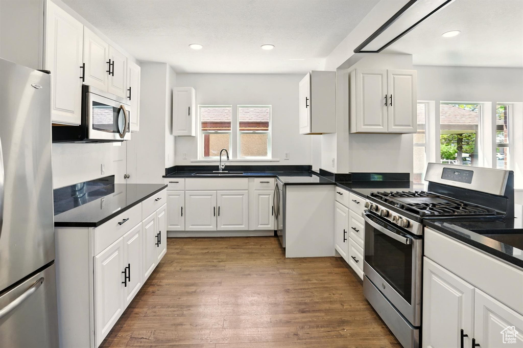 Kitchen featuring white cabinetry, appliances with stainless steel finishes, and a wealth of natural light