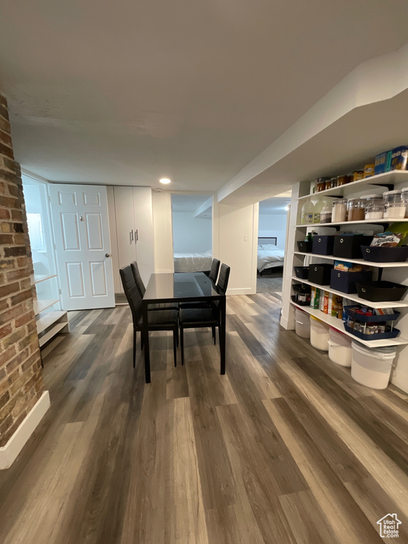 Dining area with brick wall and dark wood-style flooring