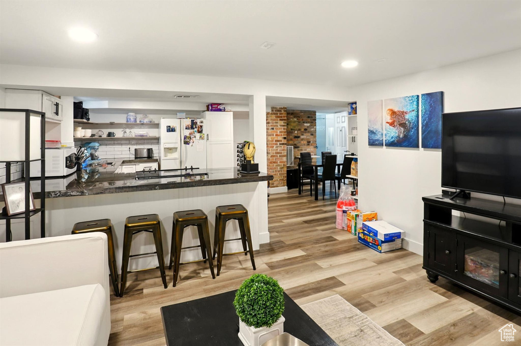Bar with recessed lighting, baseboards, light wood finished floors, and white appliances