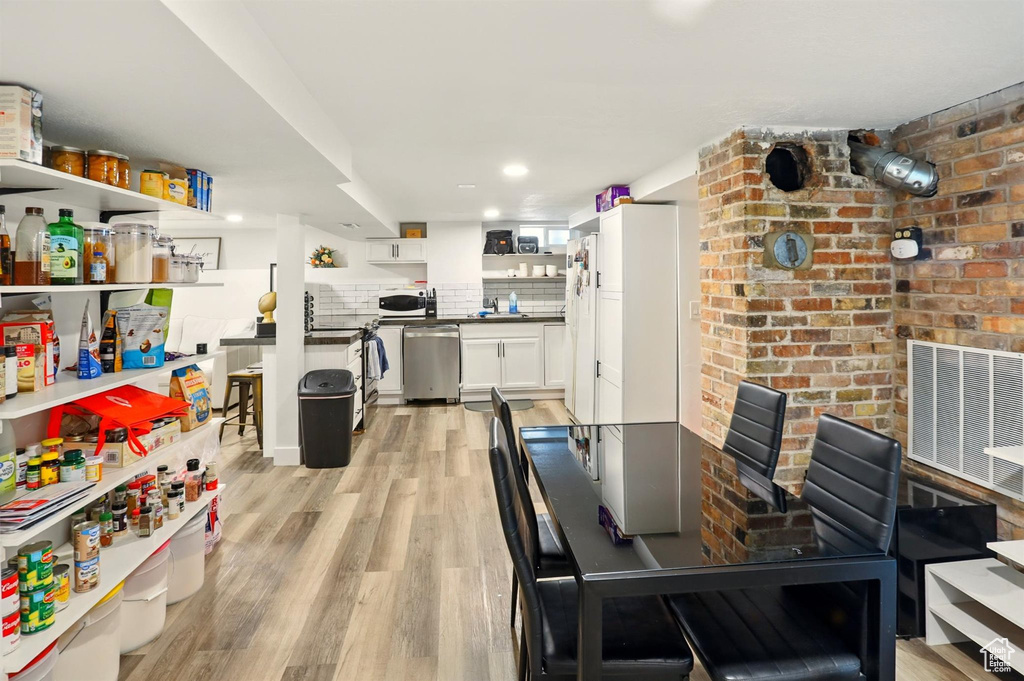 Dining space featuring light wood-style floors and visible vents