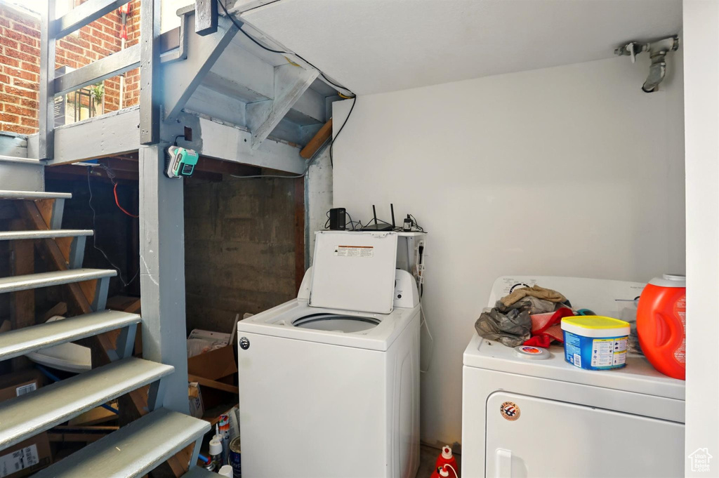 Clothes washing area featuring laundry area and washing machine and dryer